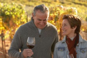 couple tasting wine at a vineyard in the fall