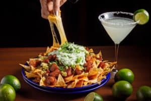 plate of nachos with a margarita