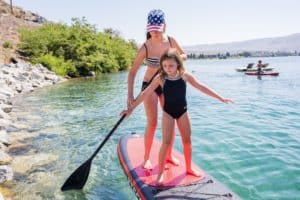 mom and daughter paddle boarding in lake chelan
